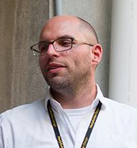 Headshot of white male, Michael Scott, smiling with glasses and white collard shirt 